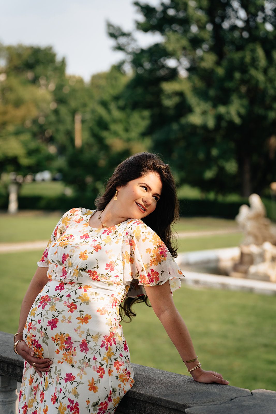 Hala in a bright floral dress standing on the museum lawn in the last of the afternoon light