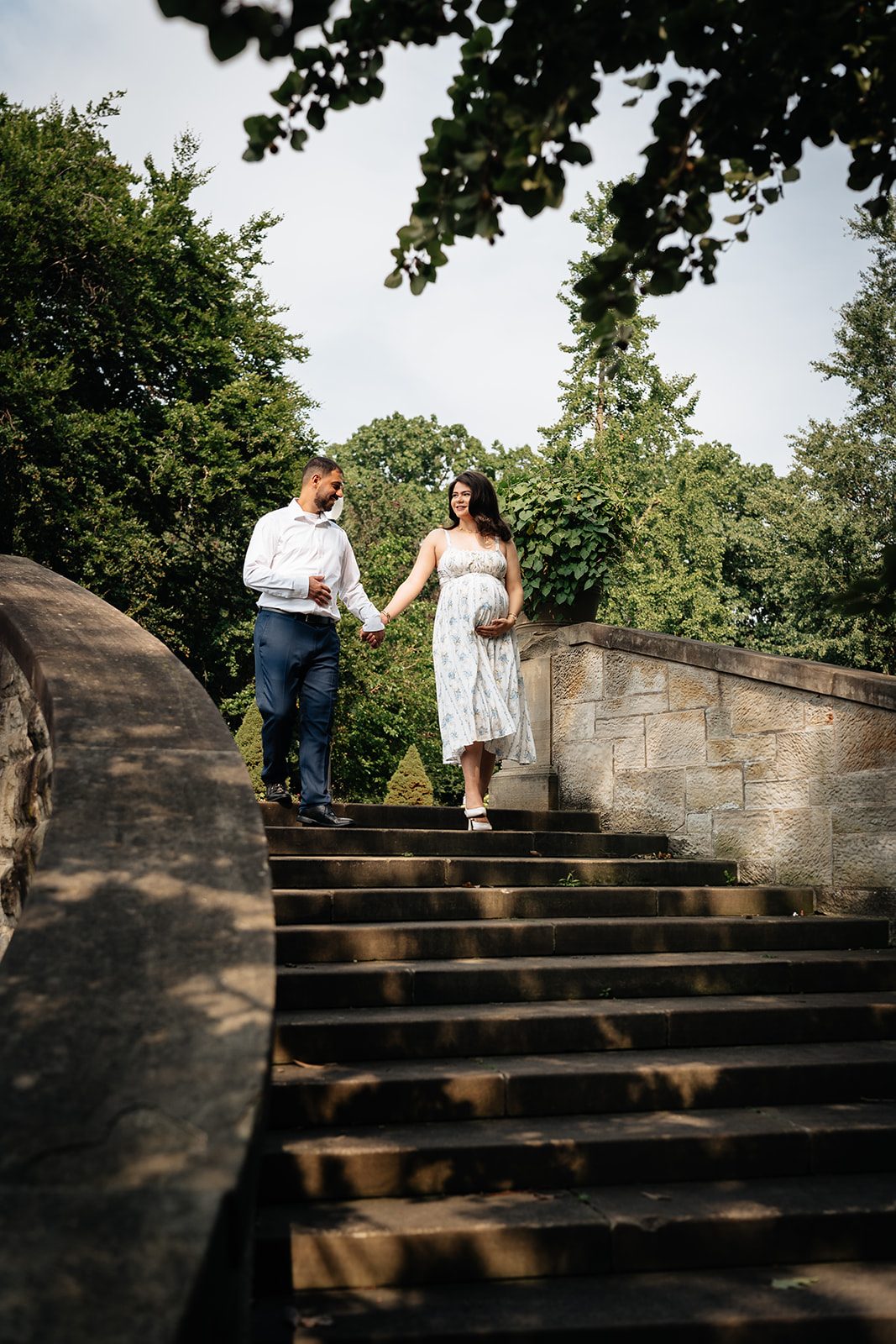 Abe leading Hala by the hand down the weathered stone staircase in the Italian Cultural Gardens
