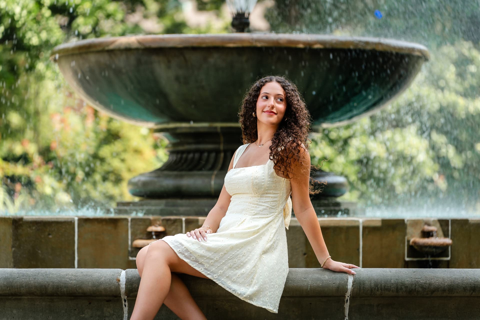 Naya standing among the stonework of Cleveland's Italian Cultural Garden during her senior portrait session